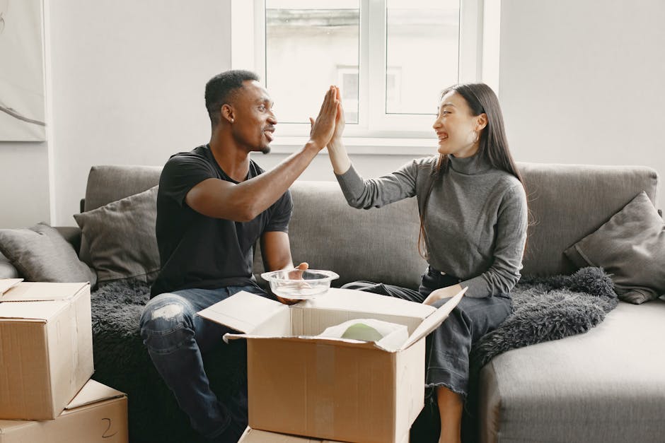 Happy couple unpacking boxes in their new apartment, enjoying the move.