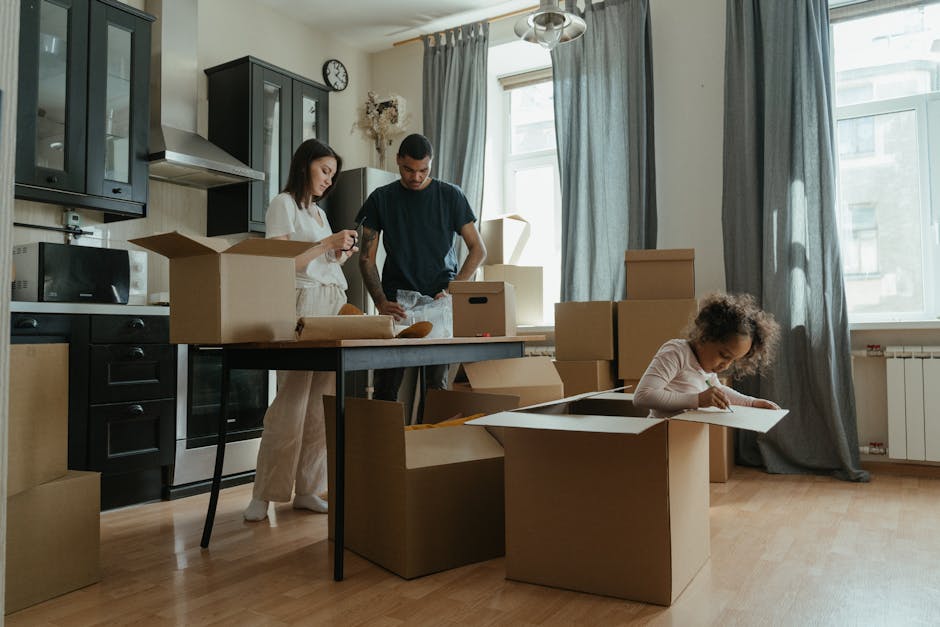A family unpacking boxes in their new apartment kitchen. Relocation and new beginnings.