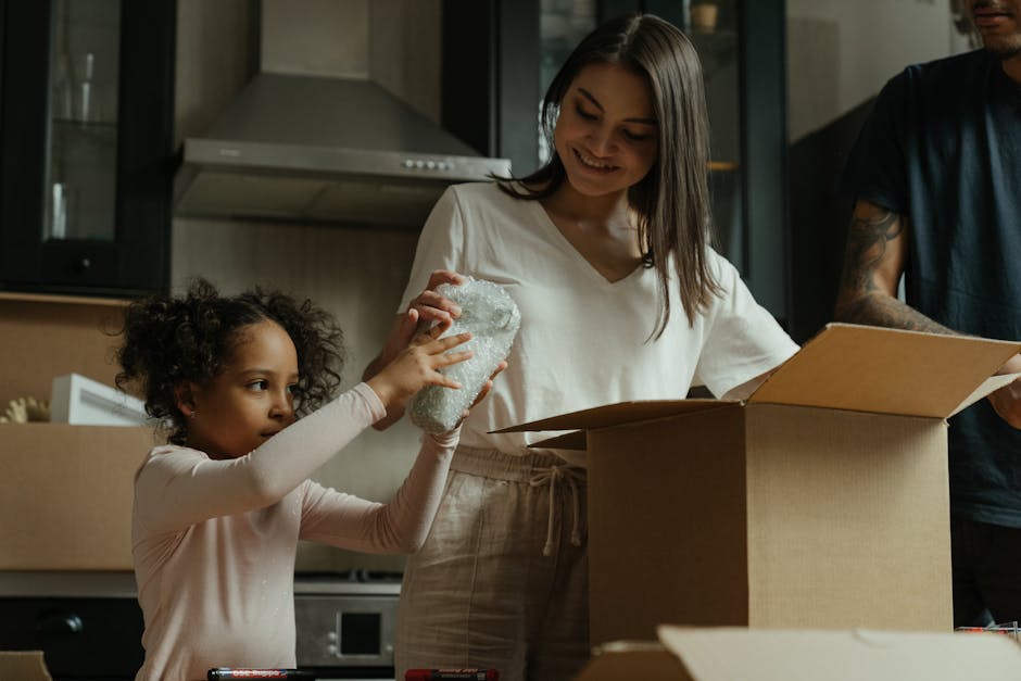 A family having fun unpacking boxes in their new home's kitchen.